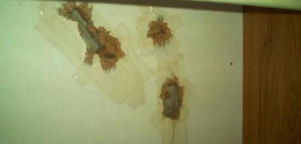 Abgeklebte Risse in einer Wand eines Hotelzimmers