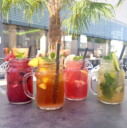 Bunte, sommerliche Getränke untere einer Palme