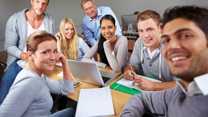 Gruppe in Zimmer mit Laptop und Schreibblöcken