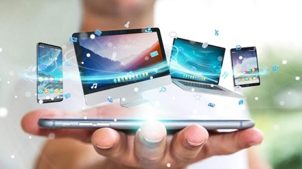 Eine Hand hält ein Smartphone auf dem diverse andere Bildschirme dargestellt sind