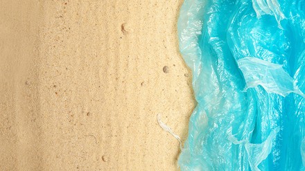 Meer aus blauen Plastiktüten geht in einen Sandstrand über