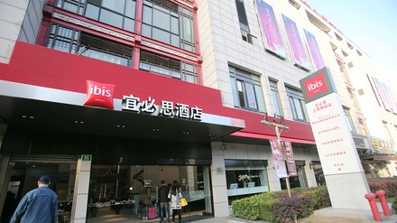 Menschen betreten das Ibis Hotel in Shanghai, China