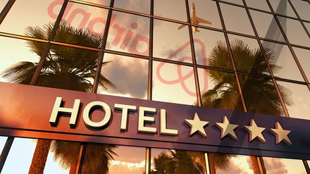 Ein Hotel, in dem sich das Airbnb-Logo spiegelt.