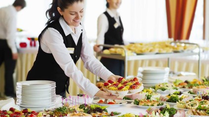 Servicekräfte dekorieren freudig ein Buffett mit köstlichen Speisen