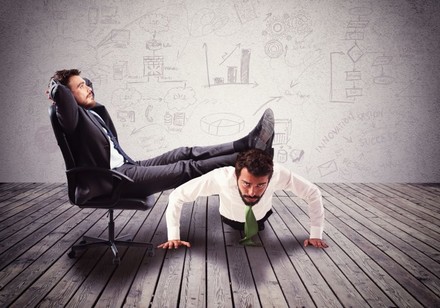 Mann legt Füße auf Rücken eines anderen Mannes