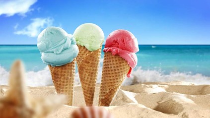Drei Waffeln mit Eis im Sand vor blauem Meer