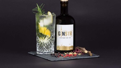 Eine Flasche Ginstr und ein Glas auf einer Steinplatte