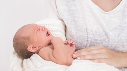 Mutter hält schreiendes Baby im Arm