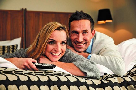 Paar auf dem Bett eines Hotelzimmers