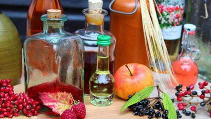 Diverse Liköre und Schnäpse auf einem Tisch mit frischem Obst