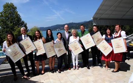 Roland Heitzeneder mit langjährigen Mitarbeitern und Lehrlingen, die ihre Urkunden hochhalten