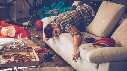 Mann schläft quer auf Sofa