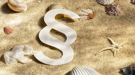 Ein Paragrafenzeichen am Strand