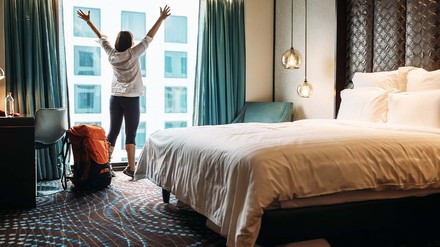 Hotelgast streckt sich freudig am Hotelfenster