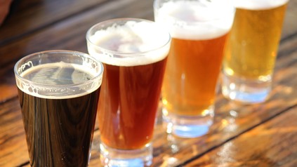 Vier Gläser voller Bier auf einem Holztisch