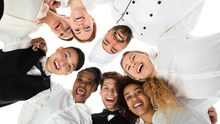 Acht junge Leute aus der Gastronomie und Hotellerie stehen im Kreis