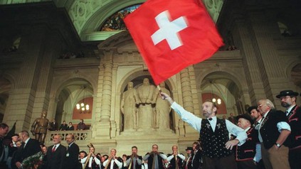 Mann hält stolz Schweizer Flagge hoch