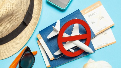 Reisepässe und Flugtickets als Hintergrund für ein Flugverbotszeichen