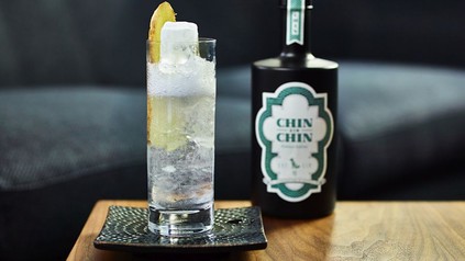 Eine Flasche Chin Chin und ein damit gefülltes Glas mit Zitrone