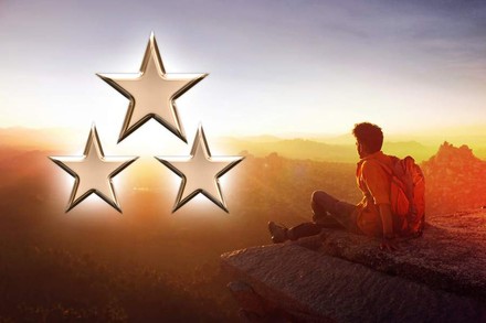 Ein Wanderer sitzt auf einem Stein, daneben sind drei Sterne abgebildet