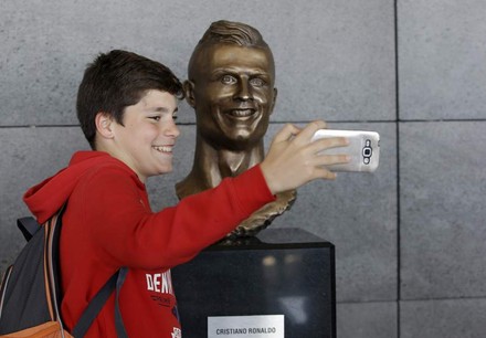 Kind fotografiert sich mit Cristiano Ronaldo Statue