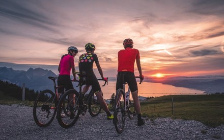 Drei Radfahrer sehen sich einen Sonnenuntergang an