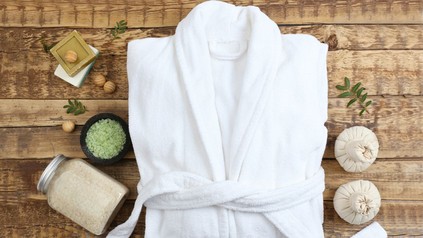 zusammengelegter Bademantel neben anderen Spa-Utensilien