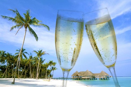 Ein Palmenstrand und zwei volle Sektgläser