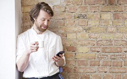 Ein entspannter Koch mit einem Smartphone in der Hand