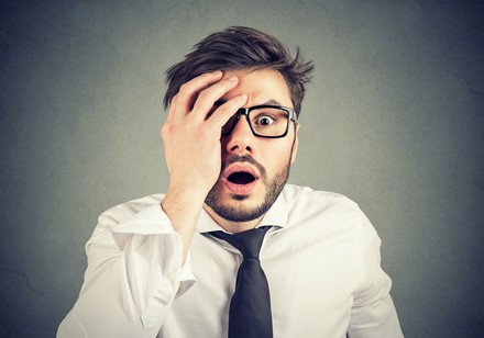 Schockierter junger Mann sieht in die Kamera