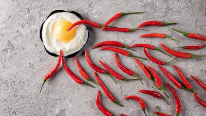 Ein Spiegelei und viele Chilischoten, die zu dem Ei hinführen