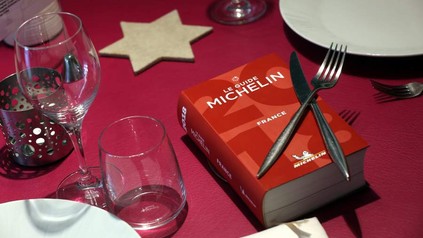 Ein Buch mit dem Titel Le Guide Michelin auf einem gedeckten Tisch
