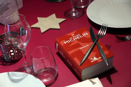 Ein Buch mit dem Titel Le Guide Michelin auf einem gedeckten Tisch