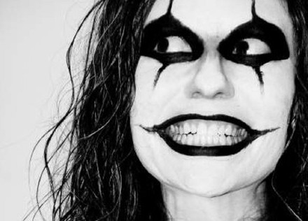 Frau mit Clownschminke grinst