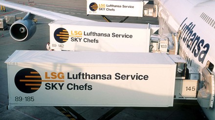Ein Flugzeug der Airline Lufthansa wird über drei Container der LSG Sky Chefs mit Speisen und Getränken beladen