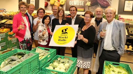Gruppe von Menschen die das Schild mit dem Logo der Markthalle hochhalten