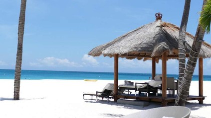 Liegestühle an einem weißen, karibischen Strand