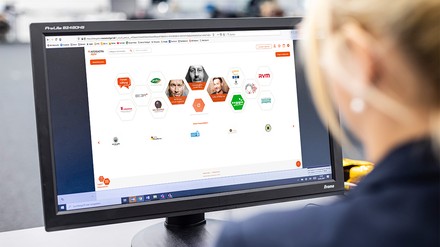 Frau sitzt vor dem PC und hat die Startseite der INTERGASTRA digital geöffnet