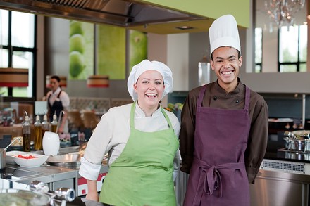 Zwei lachende junge Köche in einer Küche