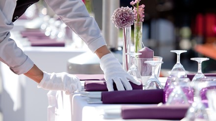 Eine Kellnerin deckt einen Tisch ein