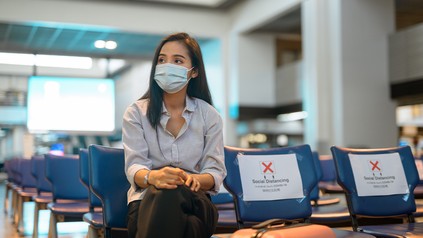 Junge Frau sitzt wartend am Flughafen