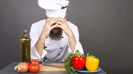 Koch hält Hände an Kopf