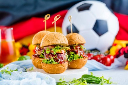 Ein Fußball und drei Hamburger vor einer deutschen Flagge