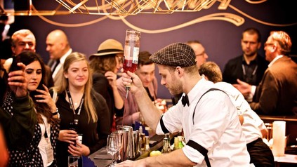 Ein Barkeeper mixt vor vielen Zuschauern einen Cocktail im Rahmen des Bar Convent Berlin.
