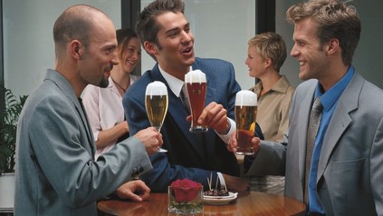 Drei Männer trinken Bier in einem Lokal.
