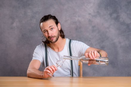 Mann schenkt sich Schnaps in ein Glas