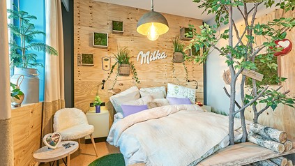 Rustikal eingerichtetes Hotelzimmer mit Milka-Schriftzug an der Wand