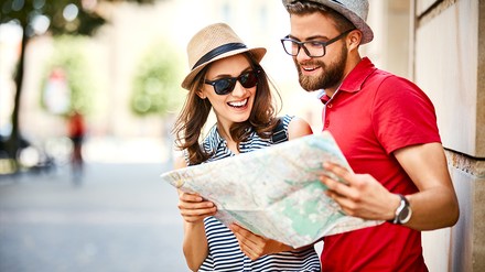 Junges Paar mit einer Stadtkarte während dem Urlaub