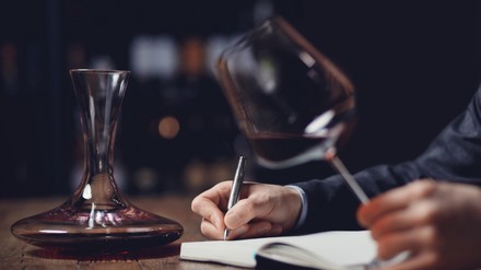 Sommelier testet Wein und macht Notizen