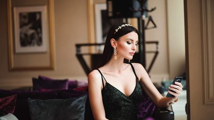 Eine Frau im Hotelzimmer mit Handy